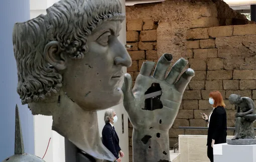 Музейный работник и статуя Колосс Константина, которая выставляется в римских Капитолийских музеях.