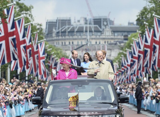 Britain's Queen Elizabeth II (L) and Britain's Prince Philip (R), Duke of Edinburgh wave to guests as they are followed in a convoy by Britain's Prince William, Duke of Cambridge, Britain's Catherine, Duchess of Cambridge and Britain's Prince Harry as they attend the Patron's Lunch on the Mall, an event to mark her 90th birthday in London on June 12, 2016.
