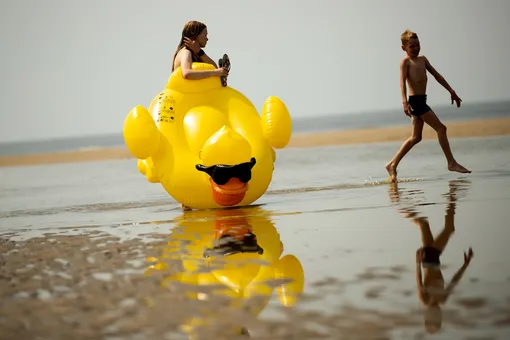 Дети играют на пляже в жаркий день в Де Хаан, Бельгия.