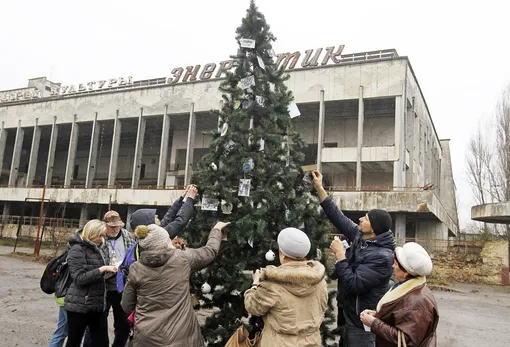 Former residents decorate a Christmas tree installed on a central square of the abandoned city of Pripyat, not far of the Chernobyl nuclear power station, Ukraine, 25 December 2019. For the first time in 33 years, the Christmas tree was set up in Pripyat at the Chornobyl Exclusion Zone. Eighteen former residents of Pripyat who had not been in their hometown for many years decorated the Cristmass tree with their family photos taken in Pripyat when the city was not yet evicted. In the early hours of 26 April 1986 the Unit 4 reactor at the Chernobyl power station blew apart. Facing nuclear disaster on unprecedented scale, Soviet authorities tried to contain the situation by sending thousands of ill-equipped men into a radioactive maelstrom. The explosion of Unit 4 of the Chernobyl nuclear power plant is still regarded the biggest accident in the history of nuclear power generation. EPA-EFE/STEPAN FRANKO