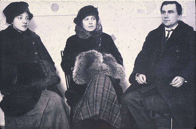 Художники Ольга Розанова, Ксения Богуславская и Казимир Малевич на «Последней кубо-футуристической выставке картин 0,10». 1915 год. Художники Ольга Розанова, Ксения Богуславская и Казимир Малевич на «Последней кубо-футуристической выставке картин 0,10». 1915 год.