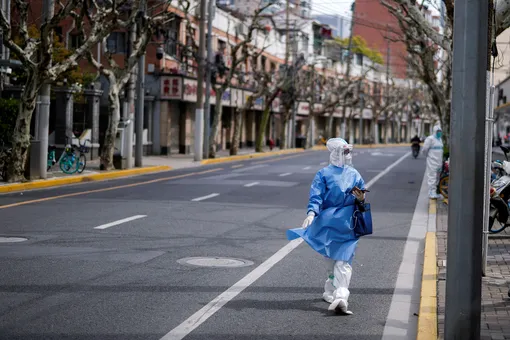 DOCUMENT DATE: April 01, 2022 A worker in a protective suit keeps watch on a street, as the second stage of a two-stage lockdown to curb the spread of the coronavirus disease (COVID-19) begins in Shanghai, China April 1, 2022. REUTERS/Aly Song