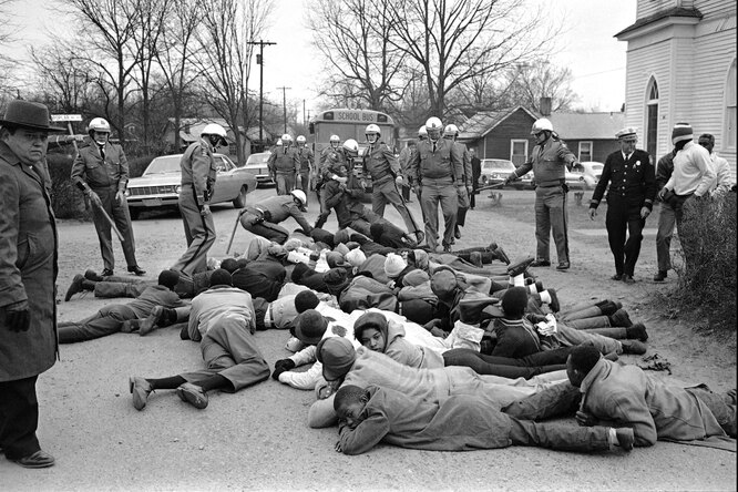 Georgia State Troopers move in on a group of demonstrators who sprawled in front of school buses again at Social Circle, Georgia, Feb. 15, 1968. The blacks were protesting school conditions they term deplorable. About 35 demonstrators were put into a prison camp bus. It was the second day of such demonstrations. КРЕДИТ