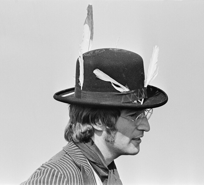 На съемках фильма «Волшебное таинственное путешествие», 1967 John Lennon (1940-1980), guitarist and singer with the Beatles, pictured wearing hat with feathers attached during filming of 'Magical Mystery Tour' in a field near Newquay in Cornwall on 14th September 1967. (Photo by )