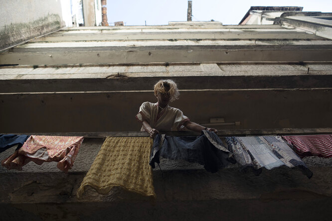 мTransgender Alex hangs clothes out to dry at the squat known as Casa Nem in Rio de Janeiro, Brazil, Wednesday, July 8, 2020. In 2016, members of the LGBTQ community led by Indianara Siqueira took over the balconied building with small bedrooms, shared bathrooms and a big common kitchen