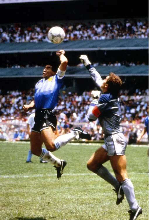 «Рука Бога» Диего Марадона «забивает» мяч рукой, обыграв Питера Шилтона