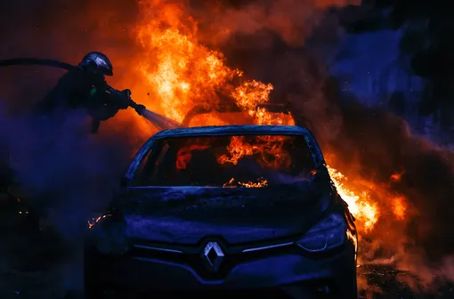 Пожарные тушат автомобиль, загоревшийся в результате столкновения «желтых жилетов» с силовиками около Триумфальной арки