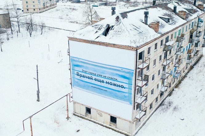 В городе-призраке Юбилейный в Пермском крае на заброшенное здание надели маску — это благотворительная акция в поддержку врачей