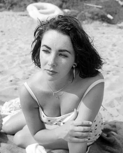 Актриса Элизабет Тейлор позирует фотографу на пляже в Малибу, штат Калифорния, 4 июля 1956 года