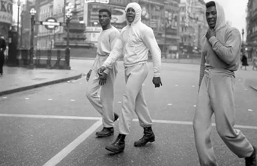 Мухаммед Али со своим братом Рахманом Али и боксером Джимми Эллисом во время утренней тренировки в Лондоне, 1963