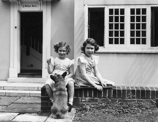Принцессы Маргарет и Елизавета играют с корги во дворе дома в Уэльсе, июнь 1936 года
