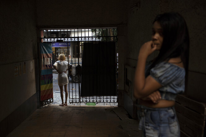 A resident of the squat Casa Nem waits at the entrance for a delivery of donated furniture, in Rio de Janeiro, Brazil, Wednesday, July 8, 2020. The six-floor building is home to members of the LGBTQ community riding out the pandemic behind closed doors.
