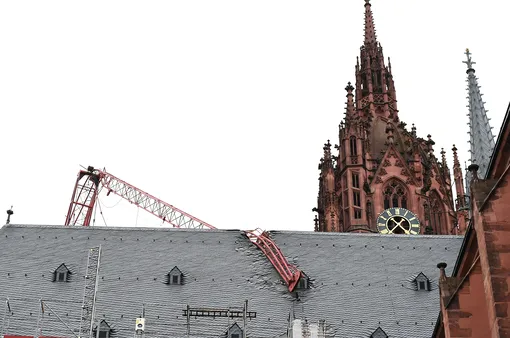Стрела строительного крана, снесенного ураганным ветром, прогнулась и упала на крышу Франкфуртского собора, Германия.