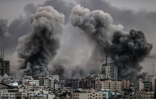Дым поднимается над зданиями во время продолжающихся израильских авиаударов в районе Аль-Римал в городе Газа, сектор Газа, 9 октября 2023 года