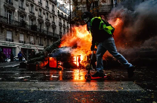 Демонстрант уезжает на самокате с протеста «желтых жилетов»