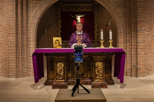 Catholic priest Catholic priest Jesus Higueras from the Santa Maria de Cana parish is seen on a smartphone during a live video streamed mass in Pozuelo de Alarcon, outskirts Madrid, Spain, Sunday, March 15, 2020. Pope Francis has praised people for their continuing efforts to help vulnerable communities, including the poor and the homeless, amid the coronavirus pandemic. The vast majority of people recover from the COVID-19. According to the World Health Organization, most people recover in about two to six weeks, depending on the severity of the illness. (AP Photo/Bernat Armangue)