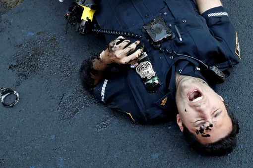 An officer from the New York Police Department is seen injured after attempting to detain a protester smearing paint on the Black Lives Matter mural outside of Trump Tower on Fifth Avenue in Manhattan, New York City, U.S., July 18, 2020