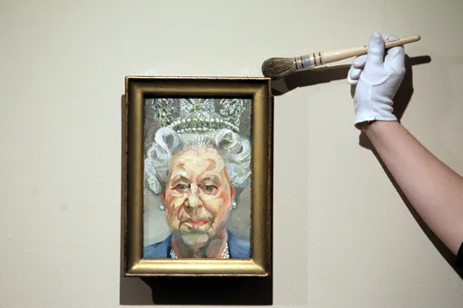 Куратор Лорен Портер смахивает пыль с портрета Елизаветы II кисти Люсьена Фрейда в рамках выставки портретов королевы в Виндзорском замке,