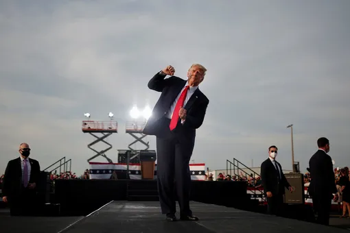 U.S. President Donald Trump reacts at the end of his campaign rally at Ocala International Airport in Ocala, Florida, U.S., October 16, 2020. Carlos Barria: «Trump's spirits always seemed to be buoyed at rallies. Trump is well known as a reality TV personality, and he's comfortable, even happy, in the spotlight. At the end of a campaign rally in Florida in October, I could see that Trump was in a good mood. He started to dance, which made the crowd go wild. I moved to the back of the stage and when he turned towards me I captured the moment.» REUTERS/Carlos Barria/File photo