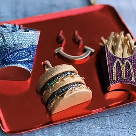 У J Balvin и McDonald's вышла совместная коллекция — это украшения в виде подноса с бургером и картошкой фри