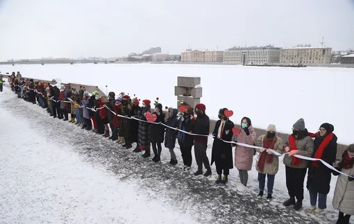 Women, some of them wearing face masks to protect against coronavirus, attend a rally in support of jailed opposition leader Alexei Navalny and his wife Yulia Navalnaya, in St. Petersburg, Russia, Sunday, Feb. 14, 2021. Participants formed a human chain in a show of solidarity with those who were detained during protests calling for the release of jailed Russian opposition leader Alexei Navalny, and the Kremlin has accused the West of meddling in Russia's affairs by denouncing the crackdown on protests. (AP Photo/Ivan Petrov)