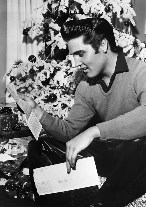 (Original Caption) 12/20/1957-Memphis, TN: Rock 'n' roll crooner Elvis Presley reads an unexpected «greeting» — a notice to report to military induction on January 20th. The idol of the teenagers is scheduled to begin making a film on the same day, however, so a studio official says that he will ask for a temporary postponement of Presley's induction. If Presley is not available for the movie, the studio and the producer will possibly lose between $300,000 and $350,000. КРЕДИТ