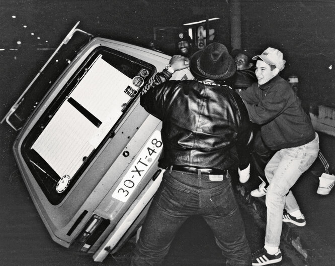 Адам Хоровиц (лицом к камере) и фанаты Beastie Boys переворачивают машину во время гастролей группы в Швейцарии, ок. 1987 г.