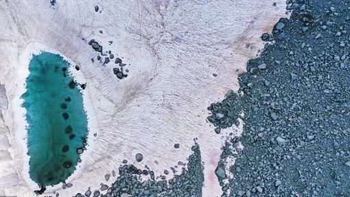 An aerial picture taken on July 3, 2020 above the Presena glacier near Pellizzano, shows pink colored snow, supposedly due to the presence of colonies of algae of the species Ancylonela nordenskioeldii from Greenland.