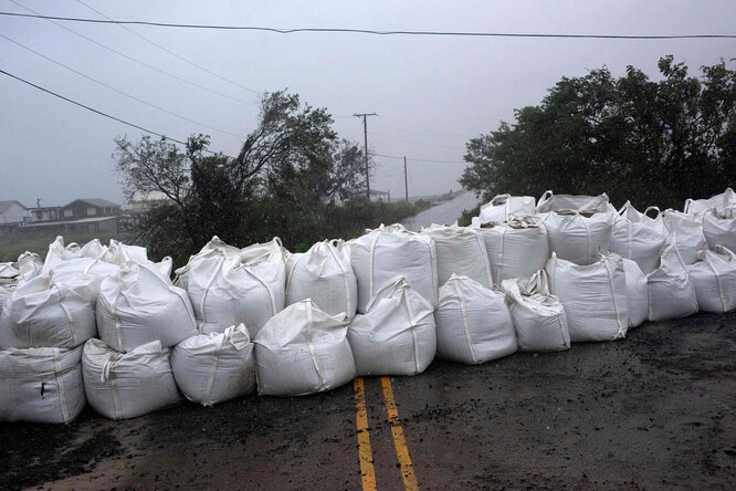 Дождь заливает мешки с песком в штате Луизиана, незадолго до начала урагана, 29 августа 2021 года.