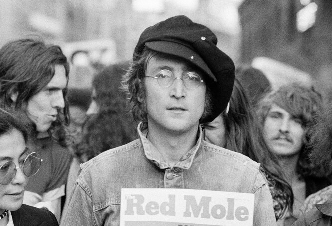 В 1975 году
Portrait of British musician John Lennon (1940 — 1980) (center) and his wife, artist and musician Yoko Ono (extreme left) as they attend an unspecified rally in Hyde Park, London, England, 1975. (Photo by )