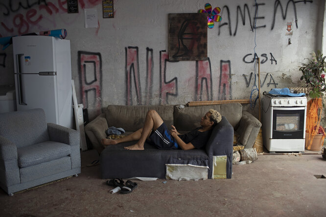 Transgender Igor rests on a couch in the courtyard of the squat known as Casa Nem, in Rio de Janeiro, Brazil, Wednesday, July 8, 2020. The six-floor building is home to members of the LGBTQ commuity riding out the pandemic behind closed doors. (AP Photo/Silvia Izquierdo)