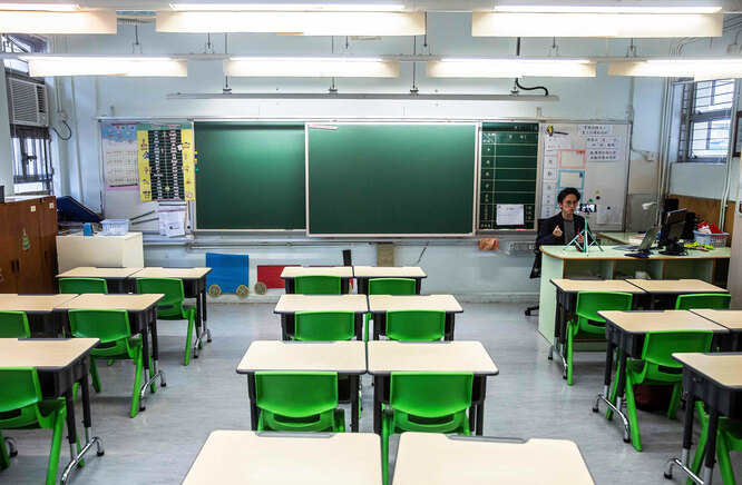 In this photo taken on March 6, 2020, primary school teacher Billy Yeung records a video lesson for his students who have had their classes suspended due to the COVID-19 coronavirus, in his empty classroom in Hong Kong. — In Hong Kong, schools have been shut since early February, with the closure now set to last until after Easter. Many teachers are turning to conference call applications to interact with students, but that requires good WiFi access and computer literacy. (Photo by ISAAC LAWRENCE / AFP) / TO GO WITH AFP STORY CHILDREN-EDUCATION-HEALTH-VIRUS-CHINA-JAPAN-SKOREA-HONG KONG-SINGAPORE,FOCUS