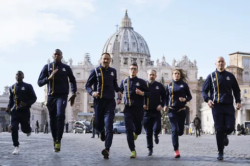 Спортсмены из Команды атлетов Ватикана бегут на фоне базилики Святого Петра, 10 января 2019. Ватикан объявил о создании собственной спортивной команды, в которую вошли порядка 60 атлетов. В их числе — охранники из Швейцарии, фармацевты, няни, священники и даже 62-летний профессор, который работает в Ватиканской апостольской библиотеке.