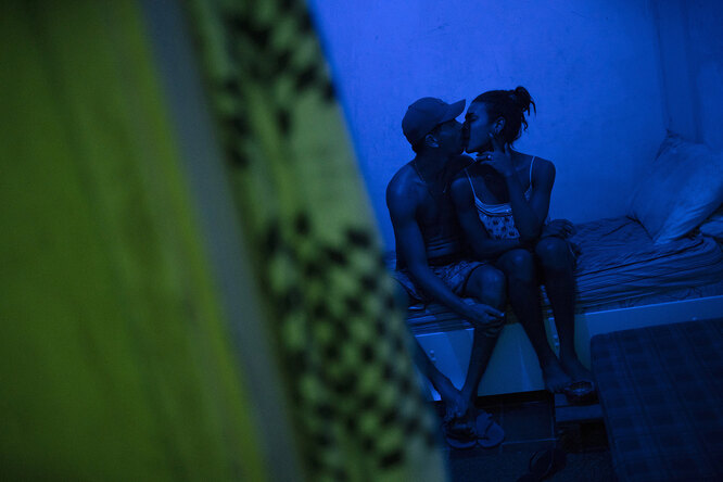 Richard Santos and his partner Lia kiss in their bedroom in the squat known as Casa Nem, occupied by members of the LGBTQ community who are in self-quarantine as a protective measure against the new coronavirus, in Rio de Janeiro, Brazil, Saturday, May 23, 2020. Several years ago Casa Nem became a shelter for LGBTQ victims of violence and those who, rejected by their families, have nowhere to live.