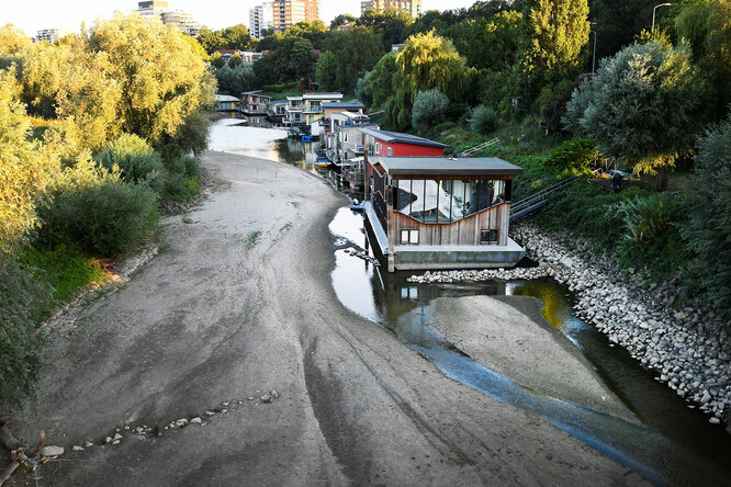 House boats are perched on a drying side channel of the Waal River due to drought in Nijmegen, Netherlands August 7, 2022. REUTERS/Piroschka van de Wouw