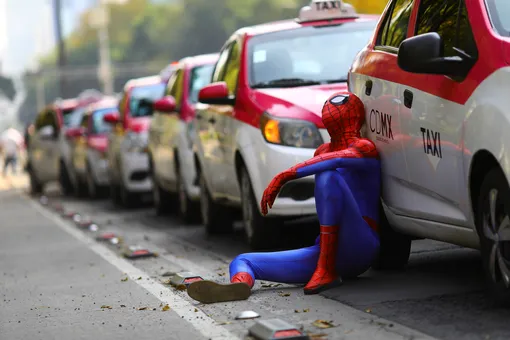 A person dressed up as Spider-Man sits next to cabs as taxi drivers hold a protest against taxi-hailing apps such as Uber, Cabify and Didi at Angel de la Independencia monument, in Mexico City, Mexico, October 12, 2020. REUTERS/Edgard Garrido TPX IMAGES OF THE DAY