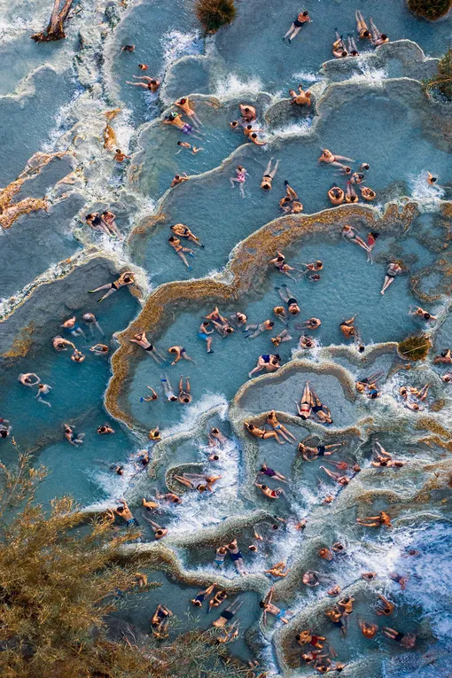 Cascate del Mulino | People CommendedTourists in the natural thermal pools in Saturnia, Tuscany, northern Italy, each one assuming a different position of relaxationPhotograph: Christian Gatti/Drone Photography Awards 2021
